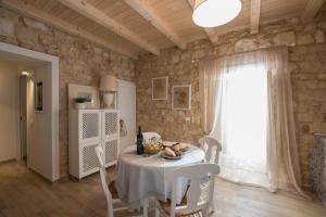 een eetkamer met een tafel en stoelen en een raam bij Casa Sabir in Modica