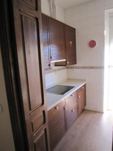 eine Küche mit Holzschränken und einer Spüle in der Unterkunft VIVIENDA SAN AGUSTÍN in Sevilla + 19 Fotos