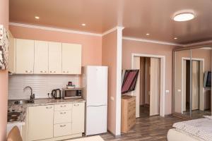 a kitchen with a refrigerator and a microwave at Cozy apartment in a new building close to the downtown in Kyiv +14 photos