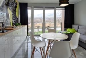 kuchnia i salon ze stołem i krzesłami w obiekcie Apartament Sun & Ski Willa K2 Black & White w mieście Karpacz