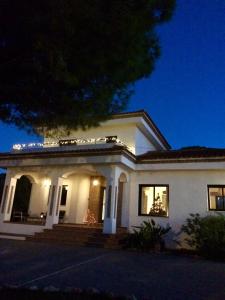 a large white house at night with lights at B&B Villa Pinos Málaga in Alhaurín de la Torre