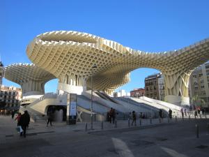 Ein Gebäude in einer Stadt mit Leuten, die um ihn herumlaufen. in der Unterkunft VIVIENDA SAN AGUSTÍN in Sevilla