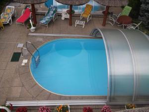 an overhead view of a swimming pool with chairs and umbrellas at Steinhaus Bed & Breakfast in Keszthely