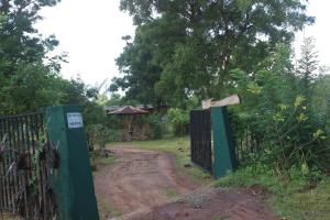 une porte menant à un chemin de terre avec un chemin de terre dans l'établissement Wilpattu Holiday Home, à Nochchiyagama