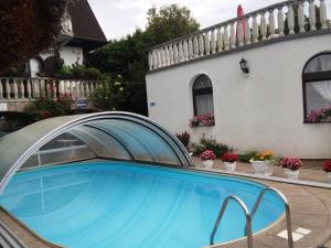 a swimming pool in front of a house at Steinhaus Bed & Breakfast in Keszthely