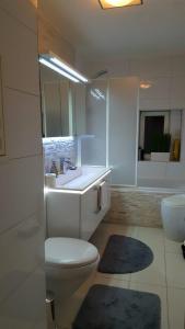 a white bathroom with a toilet and a sink at Best City Apartment in Hannover