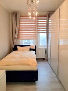 um quarto com uma cama com um lustre e uma janela em Best City Apartment em Hanôver
