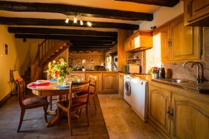 a kitchen with a table and chairs and a sink at Vue magique Coeur de Beynac in Beynac-et-Cazenac
