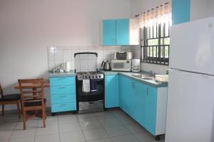 a kitchen with blue cabinets and a stove top oven at Rachel's Apartments in Paramaribo