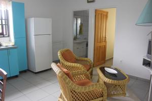 a kitchen with two chairs and a table and a refrigerator at Rachel's Apartments in Paramaribo