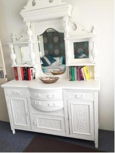 a white dresser with a mirror and books on it at Bed and Breakfast in Perth in Perth