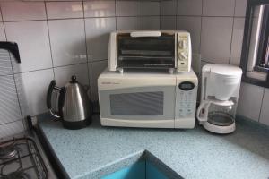 a microwave sitting on top of a counter in a kitchen at Rachel's Apartments in Paramaribo