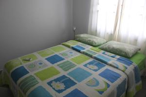 a bed with a quilt on it in a bedroom at Rachel's Apartments in Paramaribo