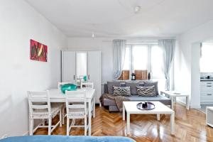 ein Wohnzimmer mit einem Sofa und einem Tisch in der Unterkunft Noctis Apartment Pańska III in Warschau
