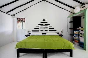 a bedroom with a green bed in a white room at Casa Alex 100m from the beach in Tulum