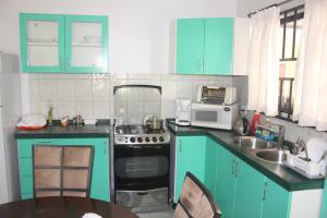 a kitchen with blue cabinets and a sink and a stove at Rachel's Apartments in Paramaribo