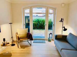 a living room with a blue couch and a glass door at Ankerplatz-Sylt @Haus Mateika in Westerland (Sylt) +18 photos