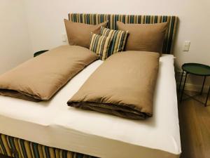 a bed with two pillows on top of it at Ankerplatz-Sylt @Haus Mateika in Westerland