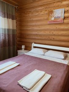 a bedroom with a bed with two towels on it at Cottage Simka in Mykulychyn