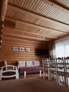 a living room with a couch and a table and chairs at Cottage Simka in Mykulychyn
