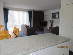 a kitchen and living room with a counter and a table at Anchorbell Holiday Apartments in Merimbula