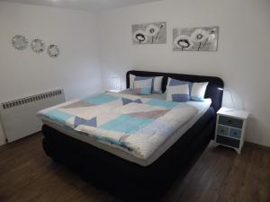 a bedroom with a large bed with blue and white sheets at Atempause in Nideggen