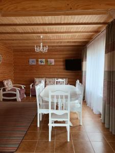 a dining room with a white table and chairs at Cottage Simka in Mykulychyn