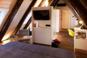 a room with a bed and a tv in an attic at Hotel Scholl in Schwäbisch Hall