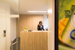 une femme qui parle sur un téléphone portable dans un bureau dans l'établissement Green Hotel, à Genk