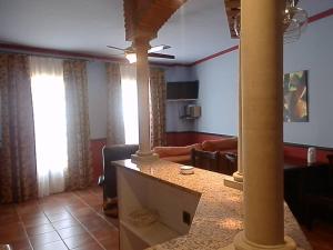 salon z kanapą i stołem z kolumną w obiekcie -2-COMO EN CASA, en centro historico de Ubeda w mieście Úbeda
