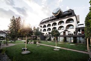 un edificio con un jardín delante de él en Gloriette Guesthouse Hotel & Restaurant en Soprabolzano