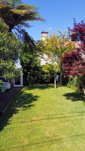 une cour avec des arbres et une maison en arrière-plan dans l'établissement Casa Magda, à Vigo