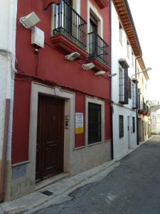 a red building with a door on a street at -2-COMO EN CASA, en centro historico de Ubeda in Úbeda
