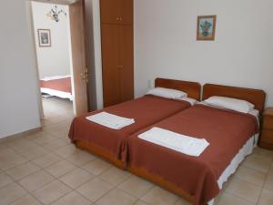 a bedroom with two beds with towels on them at Nicolas Rooms in Fiskardo