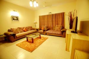a living room with two couches and a coffee table at Falcon Suites Residency Road in Bangalore