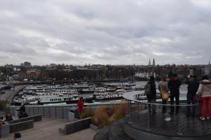 a group of people looking at a harbor with boats at MPS Flora in Amsterdam