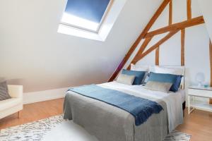 エスブリーにあるFreedomus Marne-La-Vallée "Le Briard"のベッドルーム(青い枕のベッド1台付)