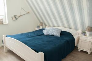 una camera con un letto e una coperta blu di Haus Steuerbord a Zirchow
