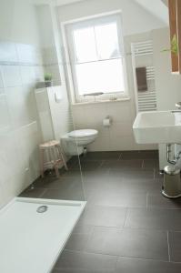 łazienka z umywalką, toaletą i oknem w obiekcie Haus Steuerbord w mieście Zirchow