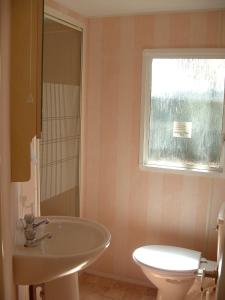a bathroom with a sink and a toilet and a window at Sunny Beach Mobile Homes Rosapineta in Rosapineta +47 photos