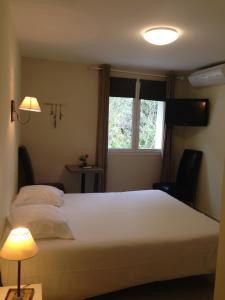 シジャンにあるLe Jardin des Oliviersのベッドルーム(大きな白いベッド1台、窓付)