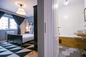 uma casa de banho com uma cama, uma banheira e um lavatório. em Downtown Wonder Apartament em Cluj-Napoca