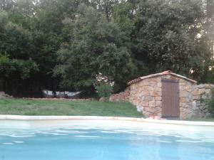 a stone building next to a swimming pool at La Maison de Campagne in Carcès