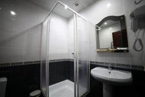 a bathroom with a glass shower and a sink at Hotel Kruiz in Krasnodar