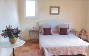 um quarto com uma cama e uma mesa com um vaso de flores em La Maison de Campagne em Carcès