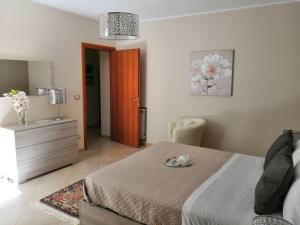 a bedroom with a bed and a dresser and a mirror at Sicilian Panoramic Apartment in Floridia