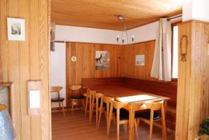 a dining room with a wooden table and chairs at grand chalet plein sud in Montgenèvre