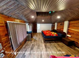a room with a bed in a wooden room at The Solitude Camp in Pālampur
