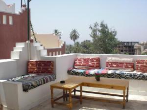 Un balcón con sofás, una mesa y escaleras. en El Fayrouz Hotel, en Luxor