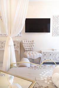 A television and/or entertainment centre at QuattroCuori Boutique Hotel & Spa